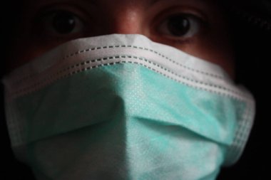 Koyu renk kazaklı, tanımlanamayan gizemli kişi İtalya 'da normal bir mavi cerrahi maske takıyor.