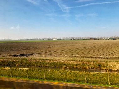 Tarım için biçilmiş toprak ya da toprak yeşil ve kahverengi bir arazi ve gökyüzü.