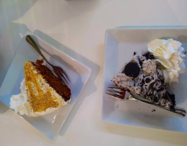 Bir dilim çikolatalı kek ve diğer lezzetli malzemeler beyaz bir masada.