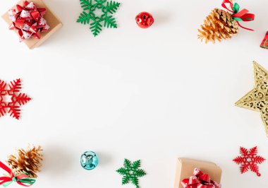 Beyaz arka planda Noel süslemeleri ve hediye kutularının üst görünümü.