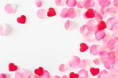 Beyaz arka planda pembe gül yaprakları ve kırmızı kalp manzarası. Sevgililer Günü konsepti..