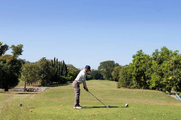 Man playing golf on a golf course.