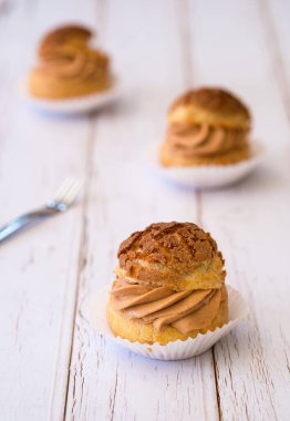 Ev yapımı choux kreması ya da ahşap arka planda çay kremalı krema..