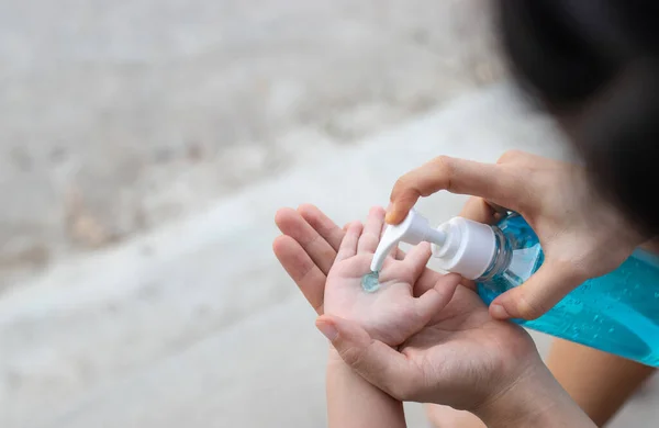 Mom cleaning baby hands with alcohol gel. protected virus concept.