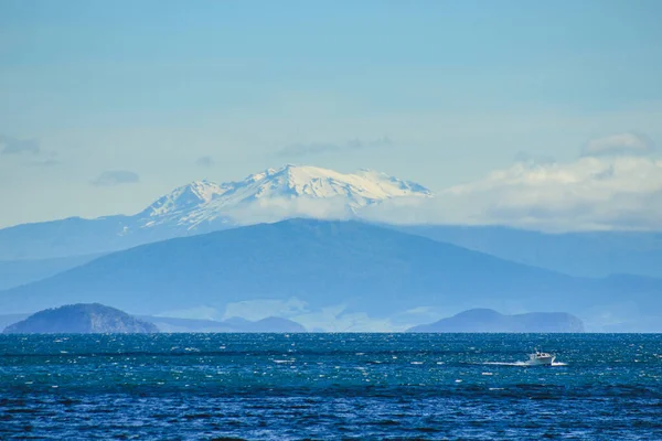 Taupo Gölü üzerinde güzel bir manzara. Arka planda karlı dağlar var. Taupo, Kuzey Adası, Yeni Zelanda.