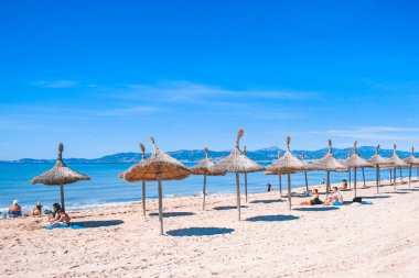 El Arenal, Mallorca, İspanya - 27 Mart 2018: İspanya 'da yaz havası. İnsanlar El Arenal 'in ünlü turistik yerindeki kumsalda güneşin tadını çıkarıyorlar.