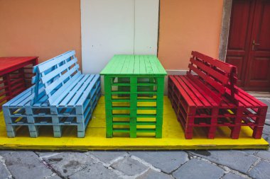 Hırvatistan 'ın Istrian Yarımadası' nın eski Pula kentindeki bir restoranın önündeki renkli sandalye ve masalar