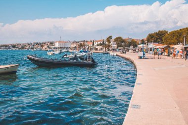 Novalja, Pag Adası, Hırvatistan - 22 Temmuz 2018: Novalja kentinin resmi gezinti alanı. Burası yazın genç turistler arasında popülerdir..
