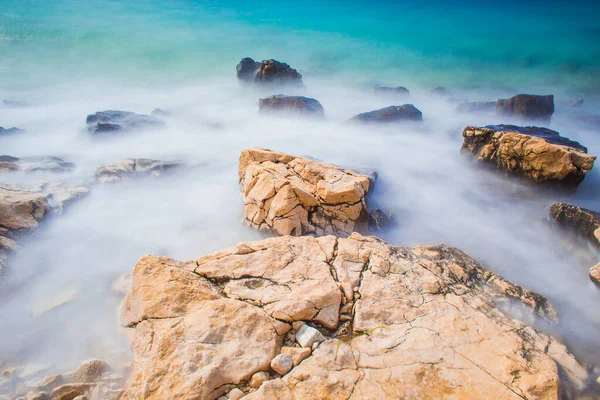 クロアチアのPag島のNovalja町の近くの小石のビーチでの岩と波 — ストック写真