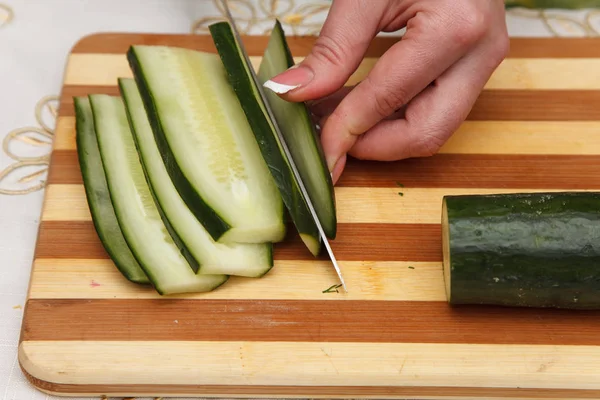 Подготовка пищи - нож режет огурец — стоковое фото