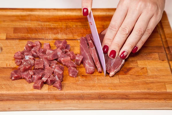 Подготовка пищи - резка сырого мяса — стоковое фото