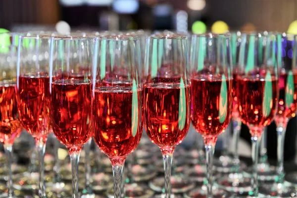 Rows of full champagne, sparkling wine and red wine glasses. Dining, drink. Catering service concept.