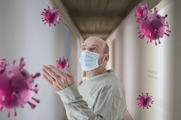Seorang dokter Kaukasia yang mengenakan topeng pelindung mencoba untuk menangkap virus Corona yang diberikan di sekelilingnya di koridor rumah sakit. — Stok Foto