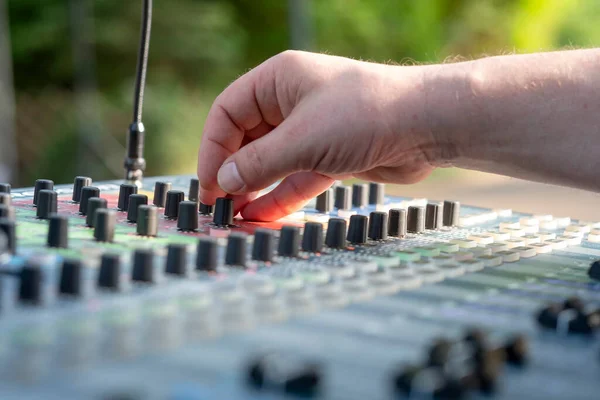 Sound engineer at mixing desk at open air - might be a wedding or a concert