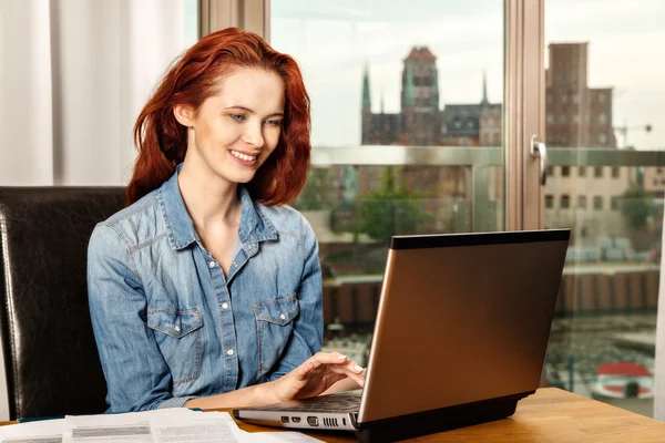 Rudowłosa młody biznes dziewczynka kobieta lub student praca z dokumentami i laptopa w pobliżu okna. — Zdjęcie stockowe