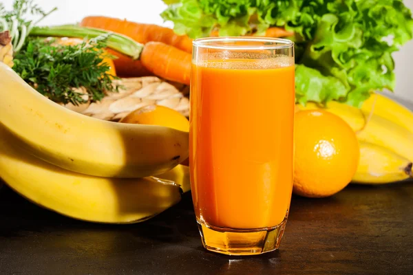 Glas frugtsaft med appelsin, gulerødder og banan - Stock-foto