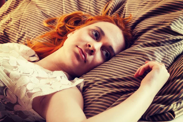 Ung kvinna sover i sängen — Stockfoto