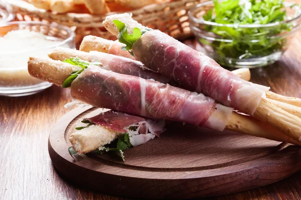 Italian grissini with ham prosciutto, mozzarella and arugula — Stock Photo, Image