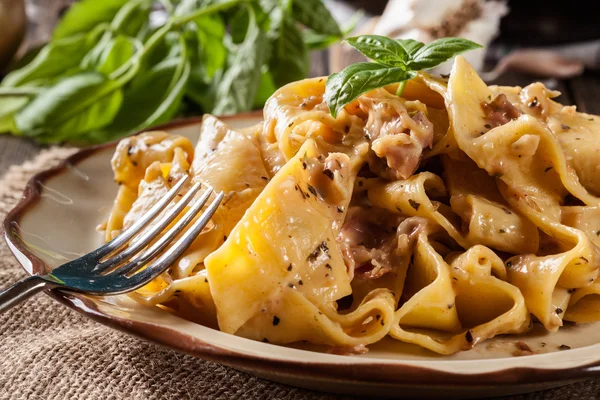Pappardelle pasta met ham en kaas saus op een bord — Stockfoto