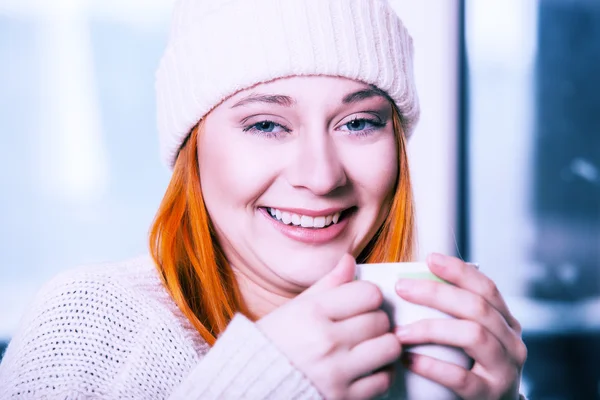 Woman wearing warm clothing and drinking hot drink — Stock Photo, Image