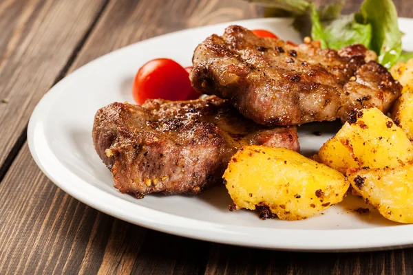 Steaks, Bratkartoffeln und Gemüsesalat — Stockfoto