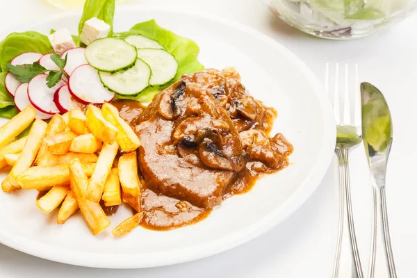 Pork chop with sauce, mushrooms and chips — Stock Photo, Image
