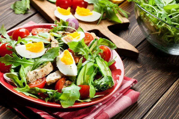 Salada fresca com frango, tomate, ovos e rúcula no prato — Fotografia de Stock