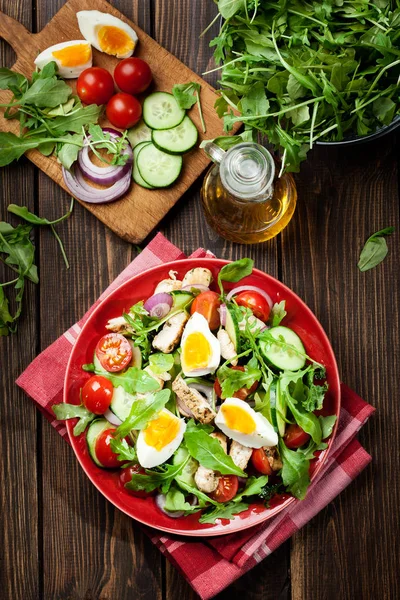 Insalata fresca con pollo, pomodori, uova e rucola sul piatto — Foto Stock
