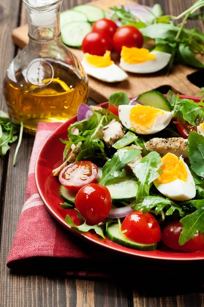 Salada fresca com frango, tomate, ovos e rúcula no prato — Fotografia de Stock