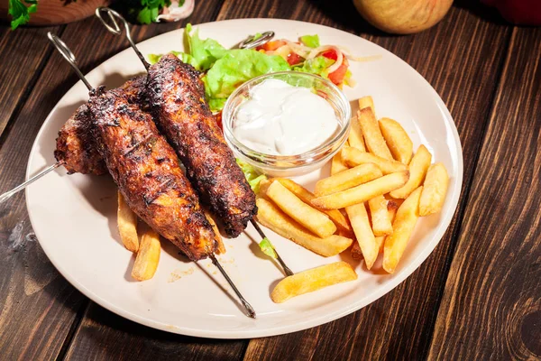 Kebab au shish grillé servi avec frites et salade — Photo