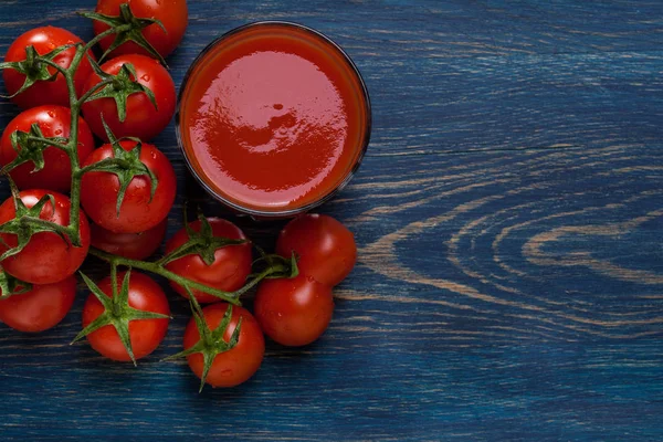 Fresh tomato juice on a blue background — Stock Photo, Image
