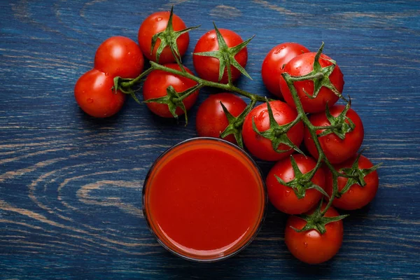 Jus de tomate frais sur fond bleu — Photo