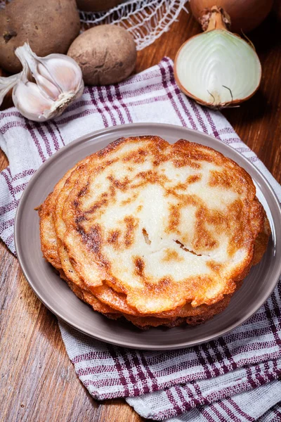 Kartoffelpuffer stapeln sich auf einem Holztisch. im Hintergrund po — Stockfoto