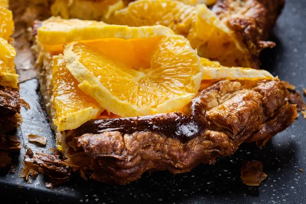Кусок пирога с сыром и нарезанный апельсин — стоковое фото