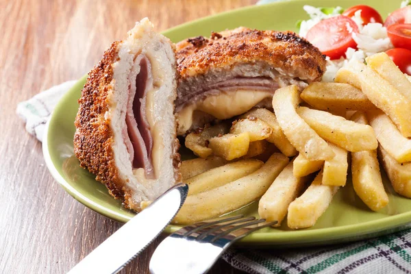 Cutlet Cordon Bleu con lomo de cerdo servido con papas fritas y ensalada —  Fotos de Stock
