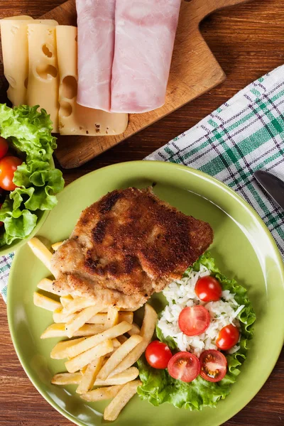 Котлет Cordon Bleu со свиной лосьон подается с картофелем фри и с — стоковое фото