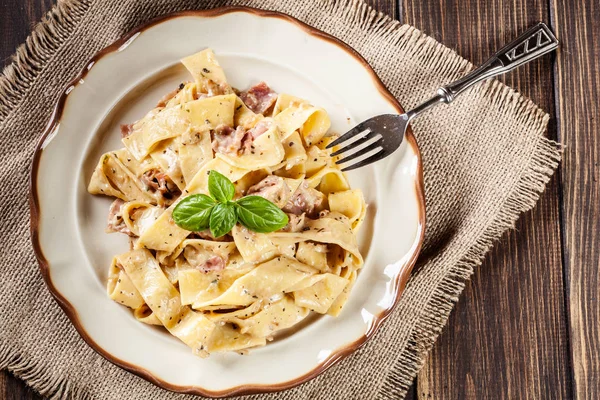 Bir plaka üzerinde jambon ve peynir soslu Pappardelle makarna — Stok fotoğraf