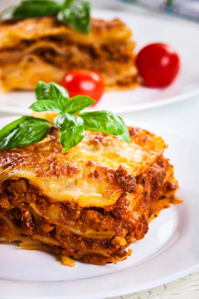 Piece of tasty hot lasagna with red win — Stock Photo, Image