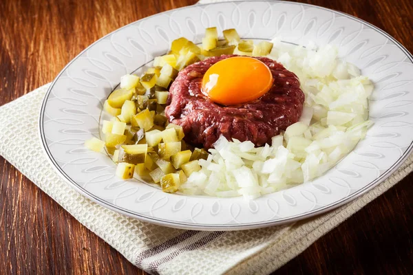 Filete tartar con yema de huevo, cebollas y encurtidos —  Fotos de Stock