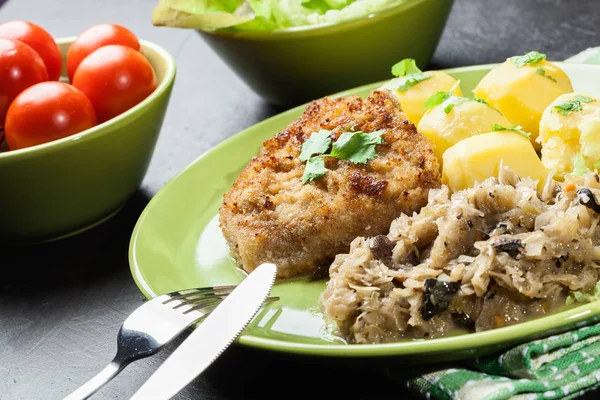 Schnitzel de cerdo frito servido con papas hervidas y sauer frito —  Fotos de Stock