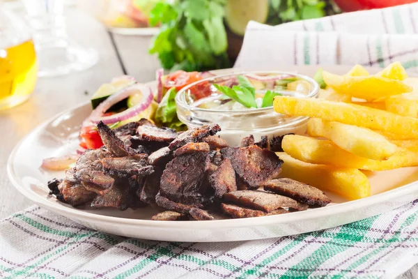 Grilled meat with French fries and fresh vegetables — Stock Photo, Image