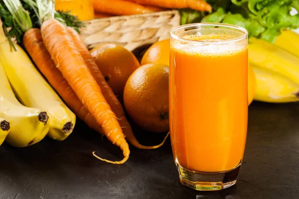 Glas vruchtensap met oranje, wortelen en banaan — Stockfoto