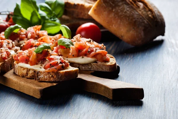 Bruschetta italiana con tomates asados, queso mozzarella y — Foto de Stock