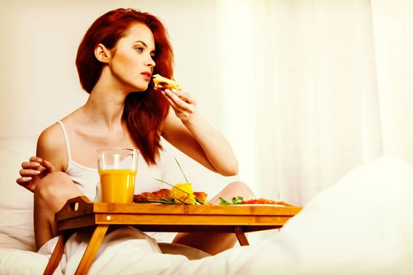 Mujer joven desayuna en la cama por la mañana — Foto de Stock
