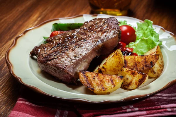 Delen van gegrilde biefstuk met gegrilde aardappelen en paprika — Stockfoto