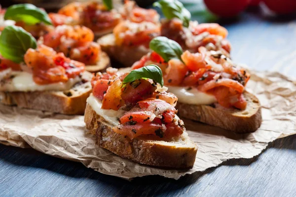 Bruschetta italiana con tomates asados, queso mozzarella y —  Fotos de Stock