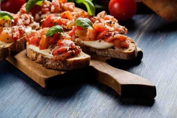 Bruschetta italiana con tomates asados, queso mozzarella y — Foto de Stock