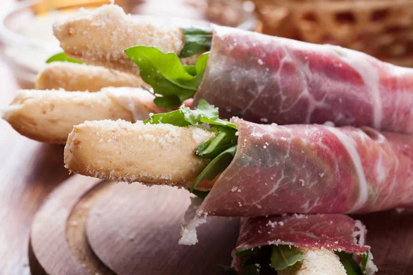 Italian grissini with ham prosciutto, mozzarella and arugula — Stock Photo, Image
