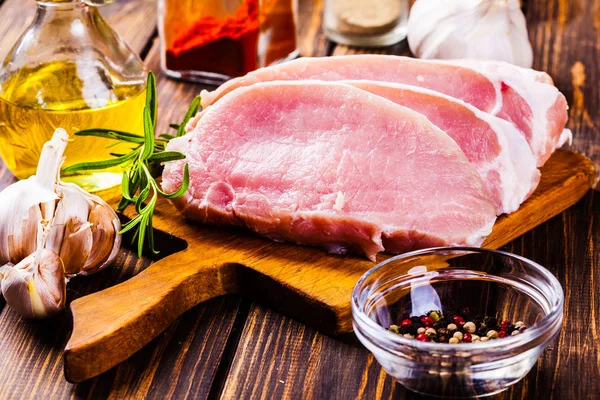Raw pork slices on a chopping board — Stock Photo, Image