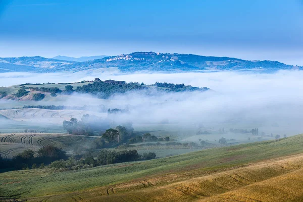 El paisaje de niebla de cuento de hadas de los campos toscanos al amanecer — Foto de Stock